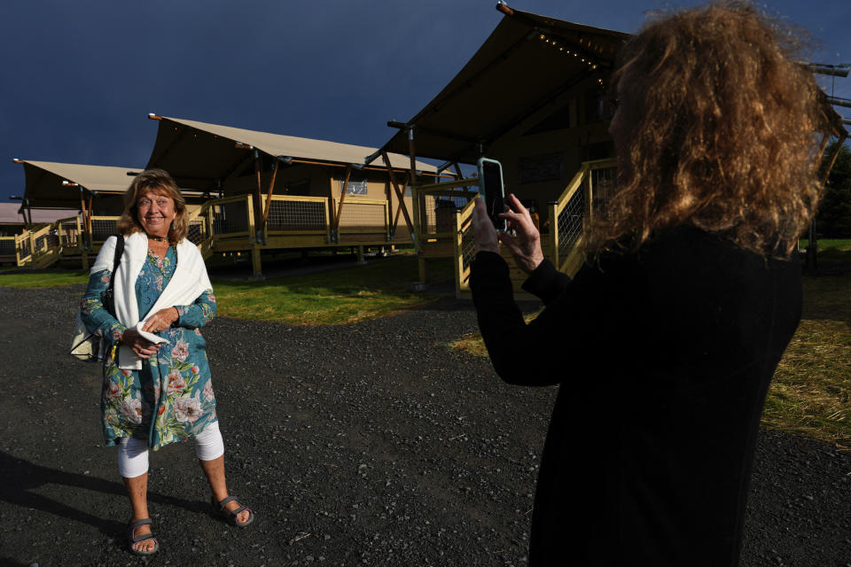 Ellen Shelburne fotografía a Beverly "Cookie" Grant frente a las tiendas de campaña de lujo en el Centro para las Artes Bethel Woods, sede de la Feria de Arte y Música de Woodstock, el viernes 14 de junio de 2024 en Bethel, Nueva York. (Foto AP/Julia Nikhinson)