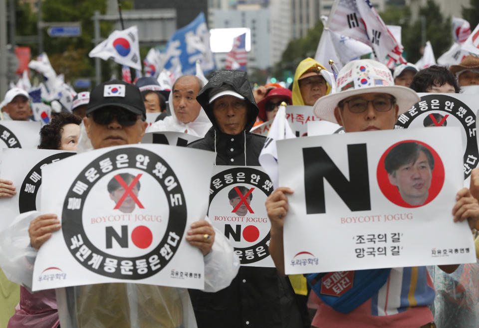 In this Sept. 7, 2019, photo, anti-government protesters stage a rally against President Moon Jae-in's nomination of Cho Kuk as justice minister in Seoul, South Korea. Cho on Monday, Oct. 14, offered to step down amid an investigation into allegations of financial crimes and academic favors surrounding his family, a scandal that has rocked Seoul's liberal government and deeply polarized national opinion. The letters read " A road of exile." (AP Photo/Ahn Young-joon)