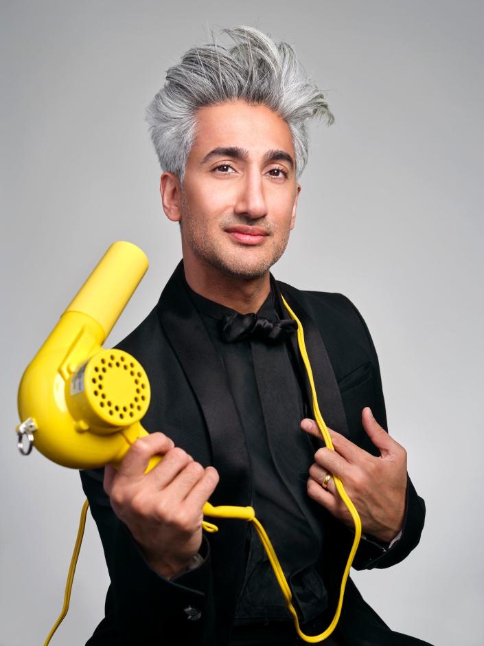 Tan France holding a yellow hairdryer.