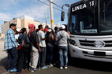 A group of Central American migrants, moving in a caravan through Mexico, get on a microbus to move to the office of Mexico's National Institute of Migration to start the legal process and get temporary residence status for humanitarian reasons, in Hermosillo, Sonora state, Mexico April 24, 2018. REUTERS/Edgard Garrido