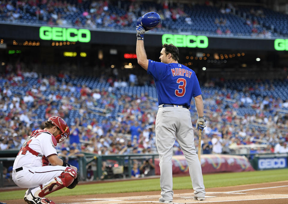 Chicago Cubs' Daniel Murphy waves his batting helmet to the crowd before his at-bat to start a baseball game against the Washington Nationals, Thursday, Sept. 6, 2018, in Washington. Murphy was traded to the Cubs from the Nationals last month. At left is Nationals catcher Spencer Kieboom at lower left. (AP Photo/Nick Wass)