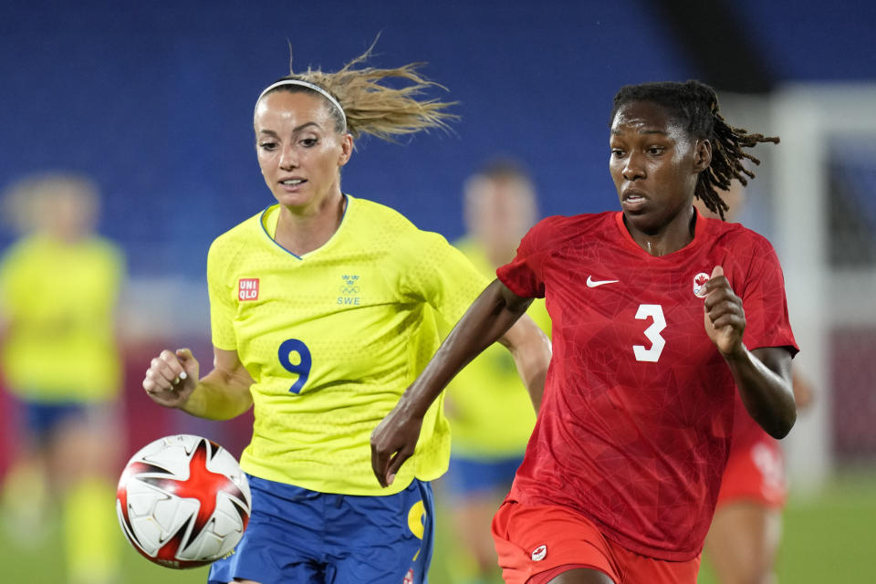 FILE - Sweden's Kosovare Asllani, left, and Canada's Kadeisha Buchanan battle for the ball during the women's final soccer match at the 2020 Summer Olympics, Friday, Aug. 6, 2021, in Yokohama, Japan. (AP Photo/Andre Penner, File)