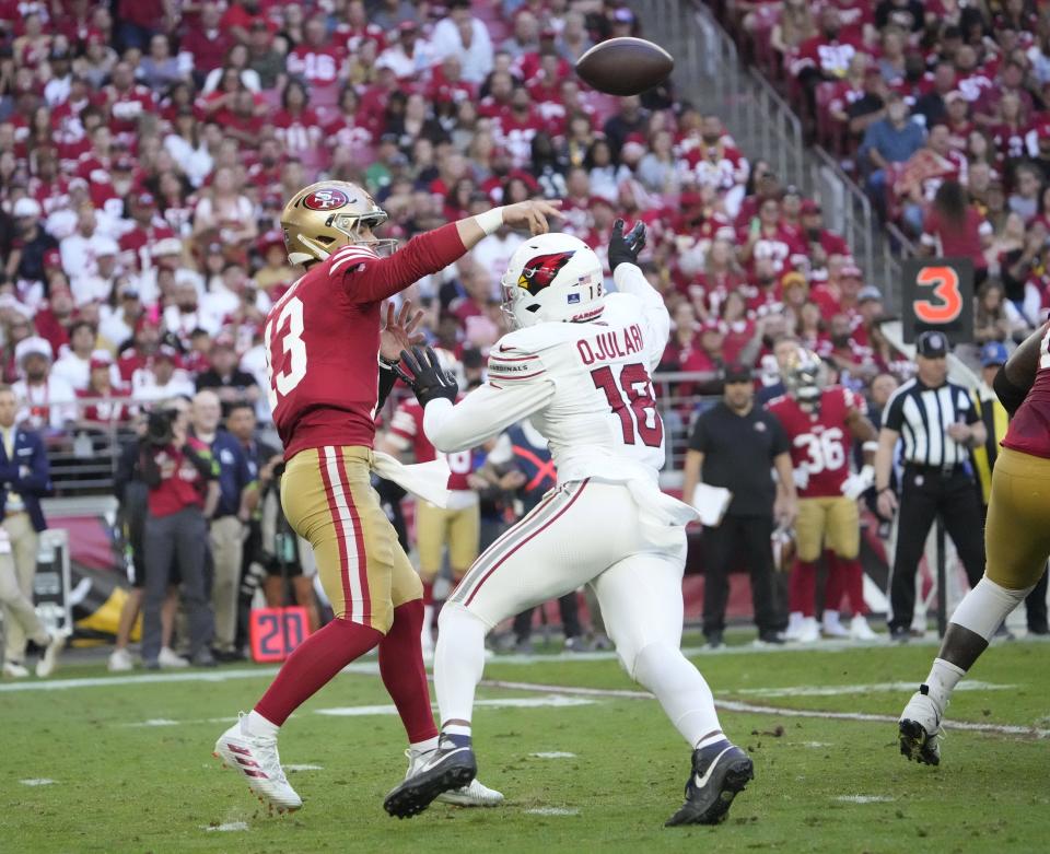 Dec 17, 2023; Glendale, Ariz, United States; San Francisco 49ers quarterback Brock Purdy (13) throws a pass while pressured by Arizona Cardinals linebacker BJ Ojulari (18) during the third quarter at State Farm Stadium.