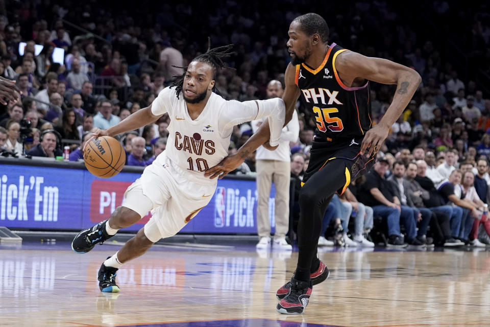 Cleveland Cavaliers guard Darius Garland (10) drives around Phoenix Suns forward Kevin Durant (35) during the second half of an NBA basketball game in Phoenix, Wednesday, April. 3, 2024. (AP Photo/Darryl Webb)