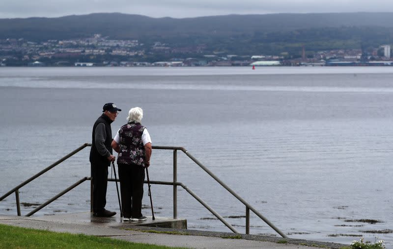 A couple look out to the Firth of Clyde near Helensburgh, Scotland