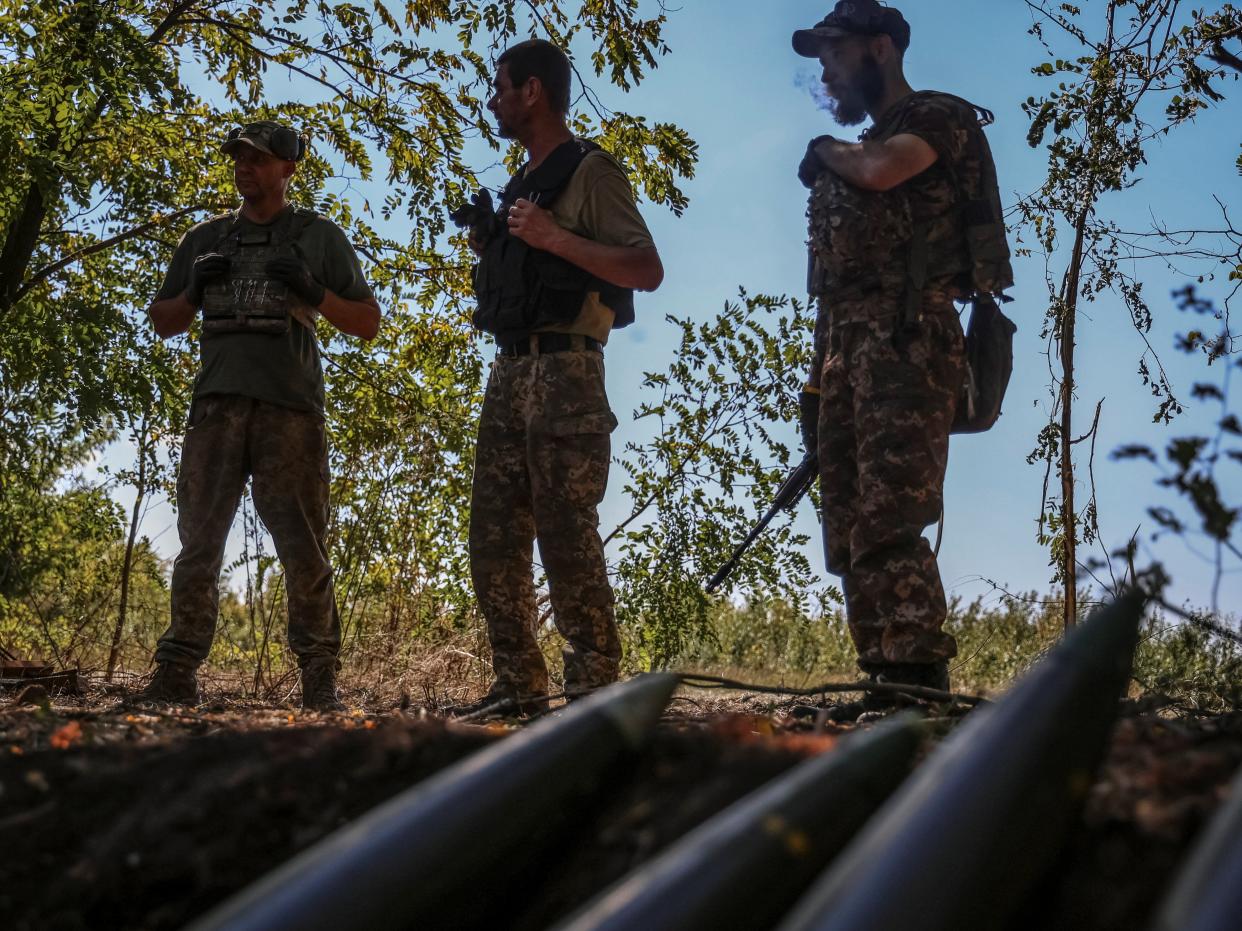 Ukrainian servicemen stand near artillery shells at a front line (REUTERS)