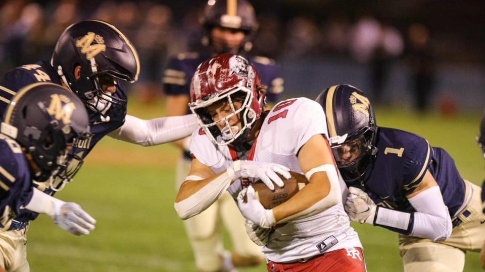 Connor Bowman is surrounded by Royals including Conner Lopez (44) and Cole Tanner (1). Mission Prep defeated Paso Robles 28-7 in a football game on Sept. 30, 2022, in San Luis Obispo.