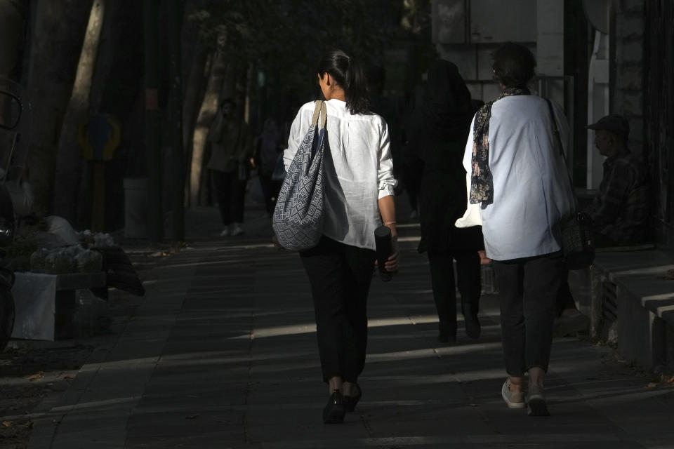 Iranian women walk in Tehran, Iran, Saturday, Aug. 5, 2023. These days, with uncovered women a common sight on Tehran streets, authorities have begun raiding companies where women employees or customers have been seen without the headscarf, or hijab. Iran's parliament is discussing a law that would increase punishments on uncovered women and the businesses they frequent. (AP Photo/Vahid Salemi)