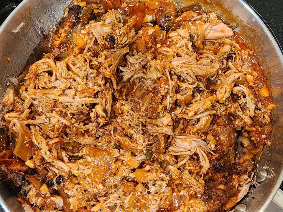 Pulled pork in a pan on the stove.