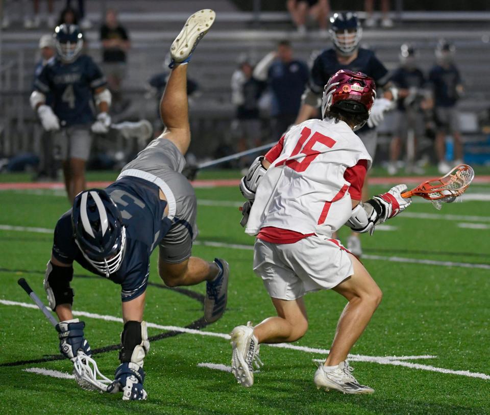 Calvary Christian's Zander Altieri (#3) takes a tumble as Cardinal Mooney Catholic's Jamison McCusker (#15) works his way around him during the Class 1A Regional semifinal playoff game hosted by Cardinal Mooney Catholic at Austin Smithers Stadium at John Heath Field in Sarasota.
