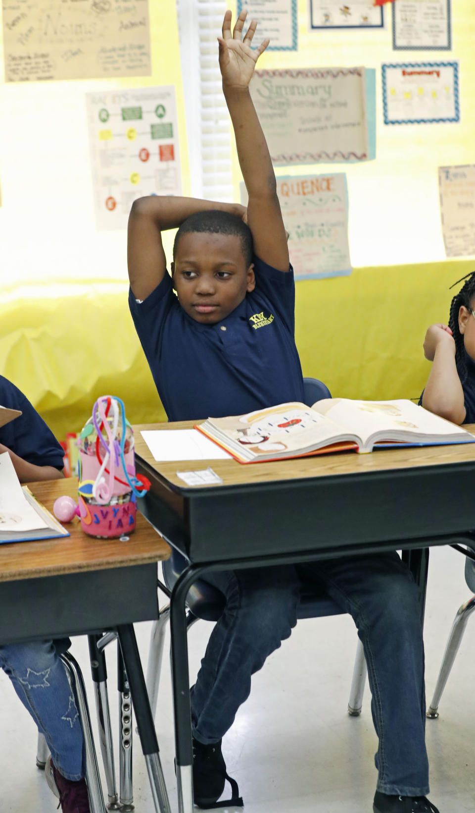 Anthony Wilder, a Key Elementary School third grade student, raises his arm with a reading question answer Thursday, April 18, 2019, in Jackson, Miss. More than 35,000 Mississippi third graders sat down in front of computers this week to take reading tests, facing a state mandate to "level up" or not advance to fourth grade. And with the bar set higher this year, state and local officials expect more students will fail the initial test, even with efforts to improve teaching. (AP Photo/Rogelio V. Solis)