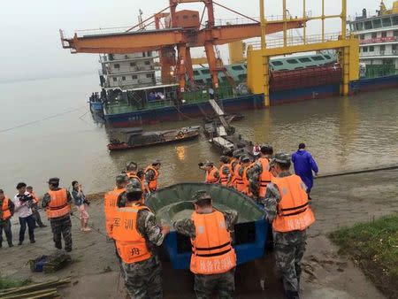 Rescue workers carry a boat to conduct a search after a ship sank at the Jianli section of Yangtze River, Hubei province, China, June 2, 2015. REUTERS/Stringer