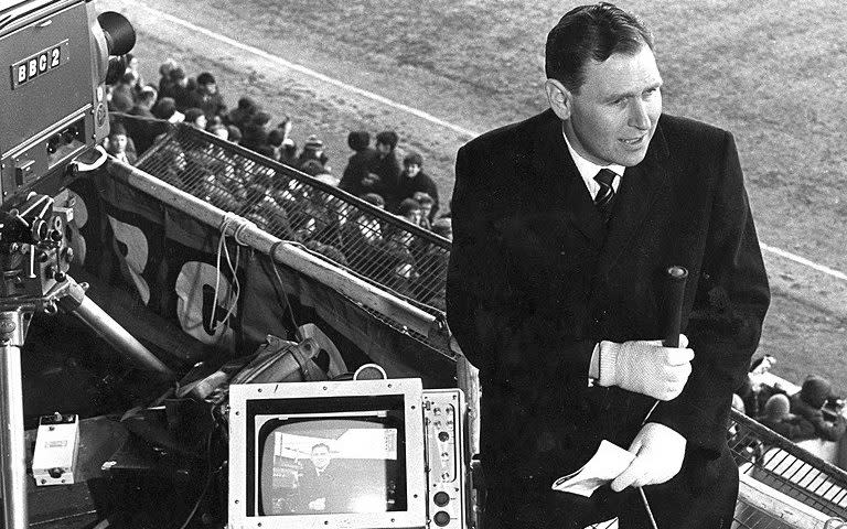 Kenneth Wolstenholme haciendo un enlace visual a la cámara antes de que comience el partido entre West Ham United y Sheffield United