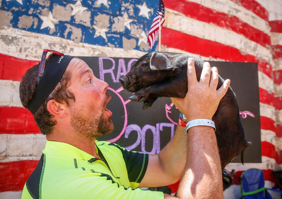 Zach Wigle of Solon, kisses Eggs, a baby pig at the Swine Cuddles booth in West Bend during RAGBRAI on Monday, July 24, 2017. The booth is a fund raising effort for the local little league baseball team.