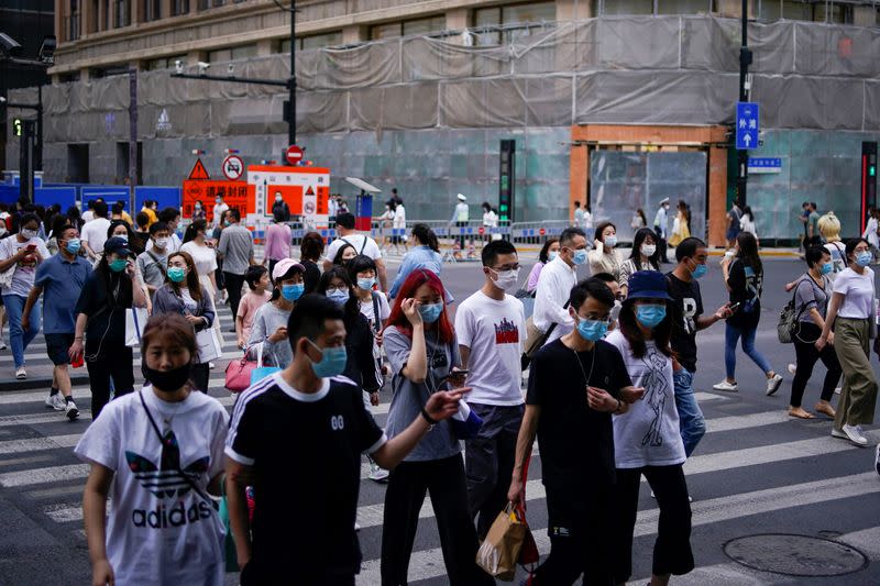 People wearing protective face masks are seen on a street following an outbreak of the novel coronavirus disease (COVID-19), in Shanghai