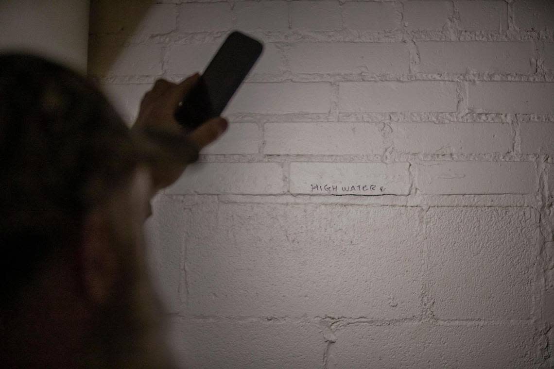 Appalshop Operations Director Roger May uses his phone to show how high flood waters reached in the organization’s archive vault in Whitesburg, Ky., during last summer’s flooding.