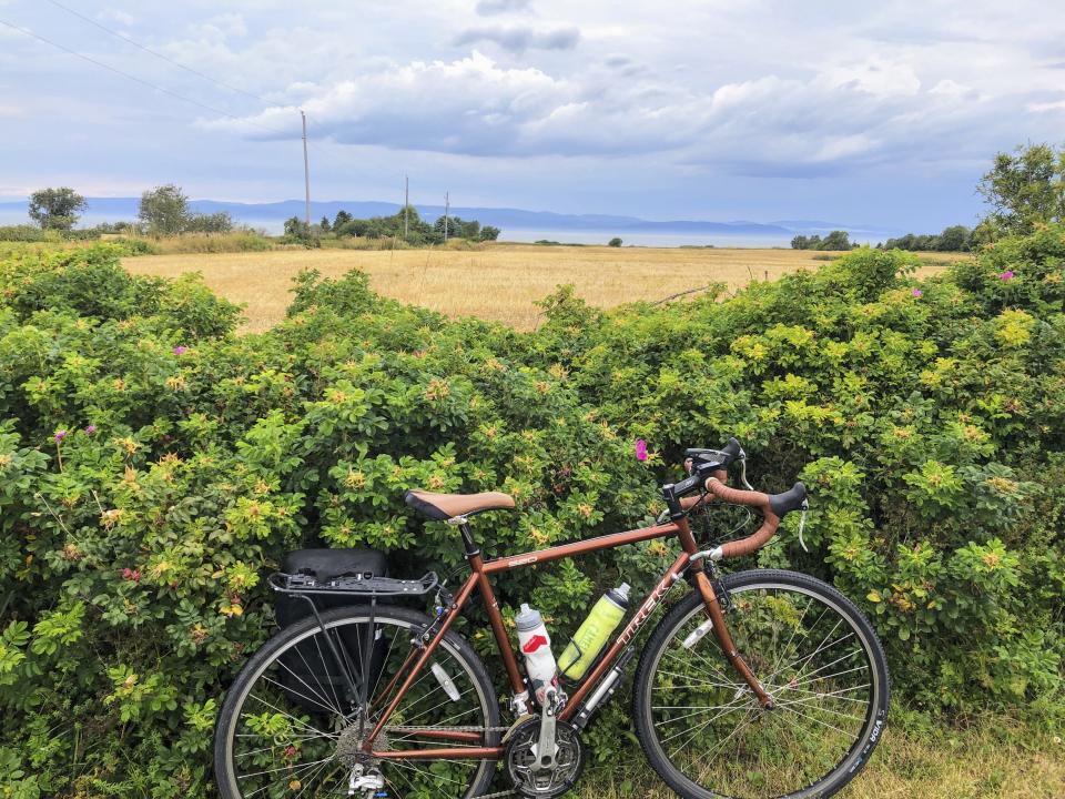 A bicycle rests against a hedge by the St. Lawrence River on Route Verte 1, one of Quebec’s prime long-distance bicycling routes, outside the village of Kamouraska, on Sept. 8, 2021. The route takes cyclists through a tapestry of storybook villages, canola fields and hedgerows of wild roses along a broad expanse of the St. Lawrence River. It’s once again accessible to Americans and other outsiders as long as they’re vaccinated and meet the other conditions for admission into Canada in the COVID era. (AP Photo/Calvin Woodward)