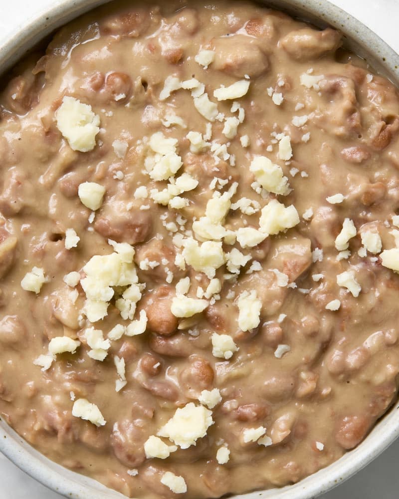 An overhead view of a bowl of refried beans