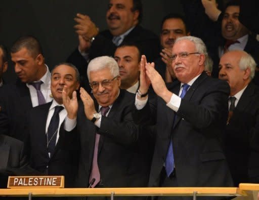 Palestinian president Mahmoud Abbas (C) and his delegation celebrate after the United Nations General Assembly voted to approve a resolution to upgrade the status of the Palestinian Authority to a non-member observer state November 29, at UN headquarters in New York. Abbas hailed the "historic" step, but warned Palestinians still faced a "long road" to getting their own country