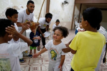 Children participate in a capoeira lesson at a local church in the Rocinha favela, in Rio de Janeiro, Brazil, July 25, 2016. REUTERS/Bruno Kelly