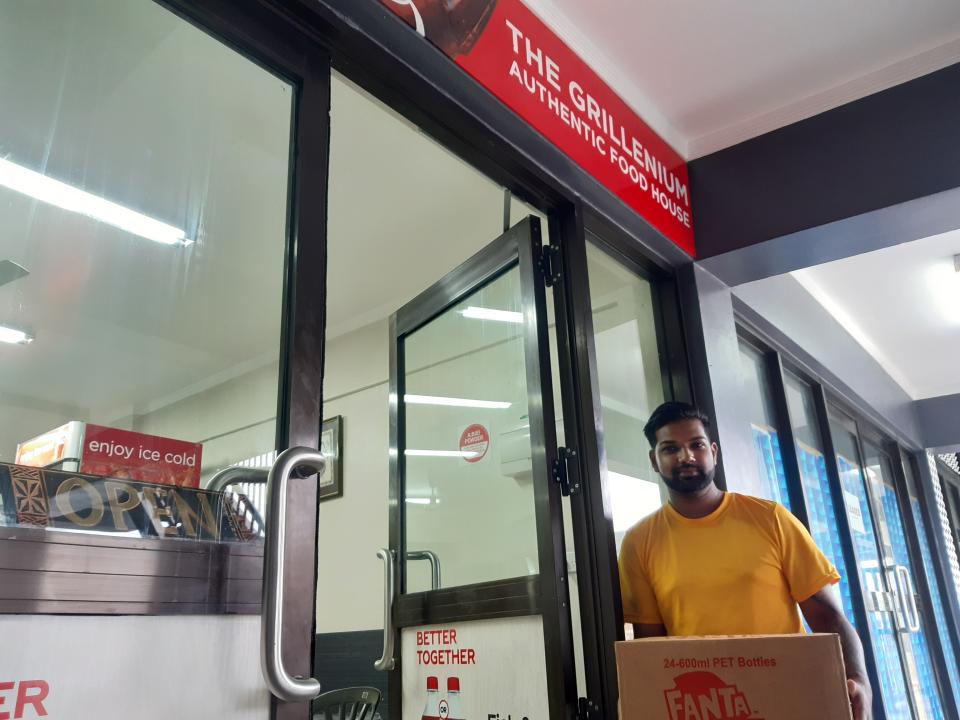Akshay Kumar, co-owner of the Grillenium Authentic Food House, tests out delivery service in the preparation for cyclone Yasa in the Samabula neighborhood of Suva, Fiji Thursday, Dec. 17, 2020. Fiji was urging people near the coast to move to higher ground Thursday ahead of a nationwide curfew as the island nation prepared for a major cyclone to hit.(AP Photo/Aileen Torres-Bennett)