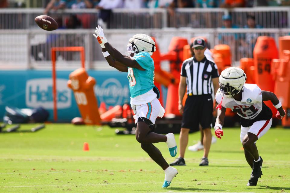 Aug 6, 2024; Miami Gardens, FL, USA; Miami Dolphins wide receiver Tyreek Hill (10) catches the football against Atlanta Falcons cornerback Anthony Johnson (43) during a joint practice at Baptist Health Training Complex. Mandatory Credit: Sam Navarro-USA TODAY Sports