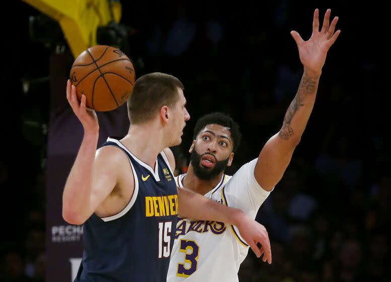 LOS ANGELES, CALIF. - DEC. 22, 2019. Lakers forward Anthony Davis defends against Nuggets center Nikola Jokic in the first quarter Sunday night, Dec. 22, 2019, at Staples Center in Los Angeles (Luis Sinco/Los Angeles Times)