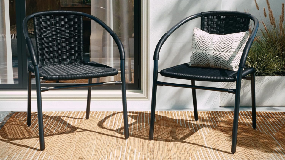 the black rattan patio chairs on an outdoor patio