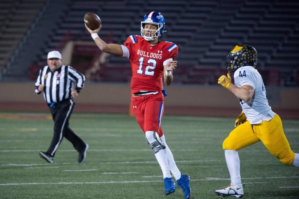 The Oak Ridge Trojans’ Markus Hoffmann (44) puts pressure on Folsom Bulldogs quarterback Austin Mack (12) as he looks to pass downfield during the first quarter in the CIF Sac-Joaquin Division I section championship playoff game Friday at Hughes Stadium at Sacramento City College.