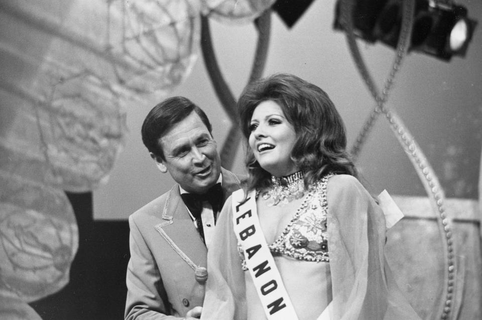 FILE - Georgina Rizk, from Beirut, Lebanon, reacts after being named Miss Universe as pageant host Bob Barker talks to her at the Miami Beach Auditorium, Fla., July 24, 1971. (AP Photo/File)