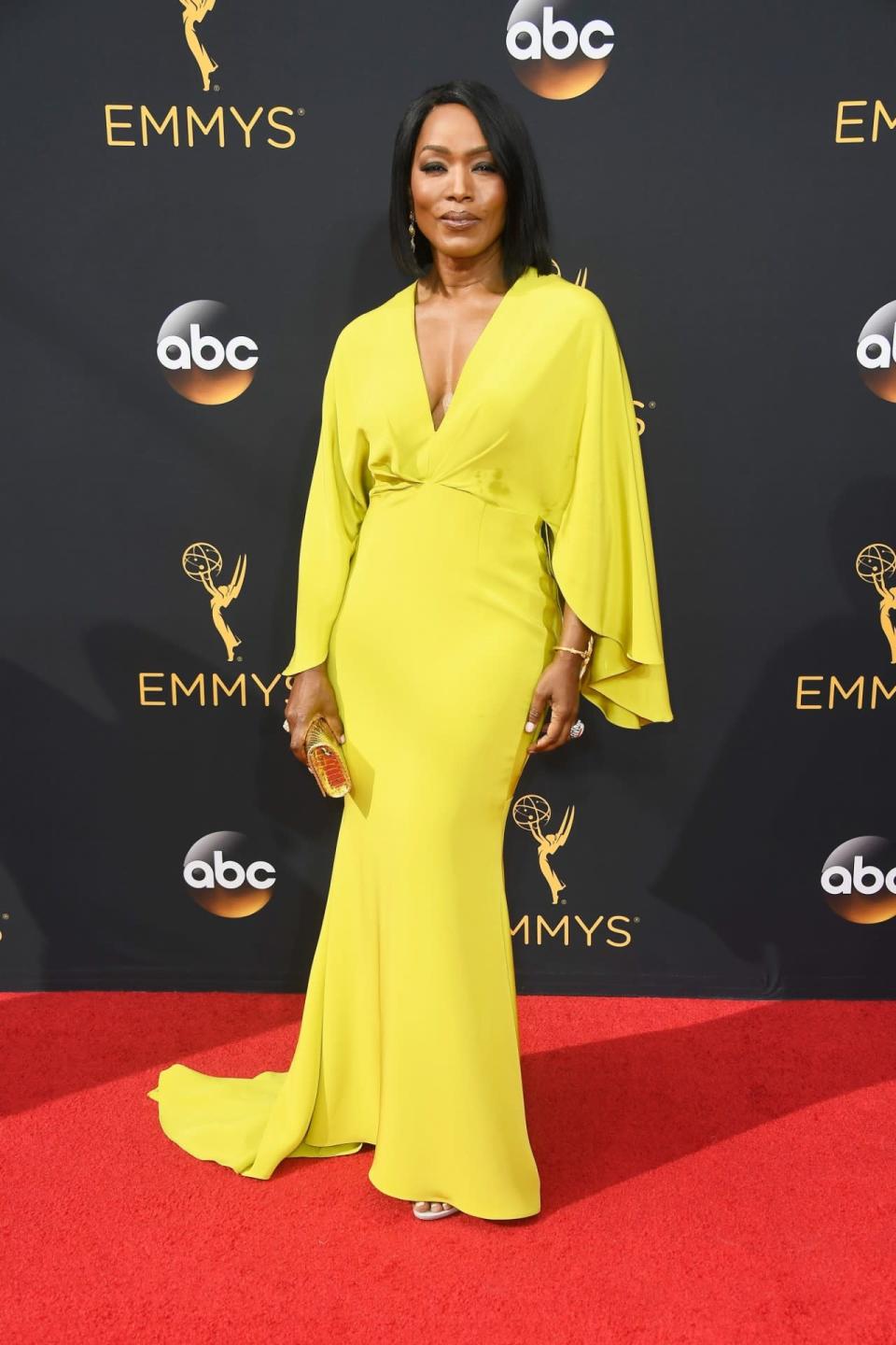 Angela Bassett in a custom chartreuse cape-sleeve gown