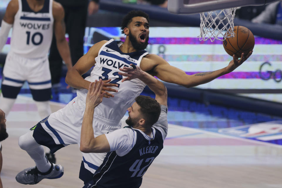 Minnesota Timberwolves center Karl-Anthony Towns (32) drives to the basket over Dallas Mavericks forward Maxi Kleber (42) during the second half in Game 4 of the NBA basketball Western Conference finals, Tuesday, May 28, 2024, in Dallas. (AP Photo/Gareth Patterson)