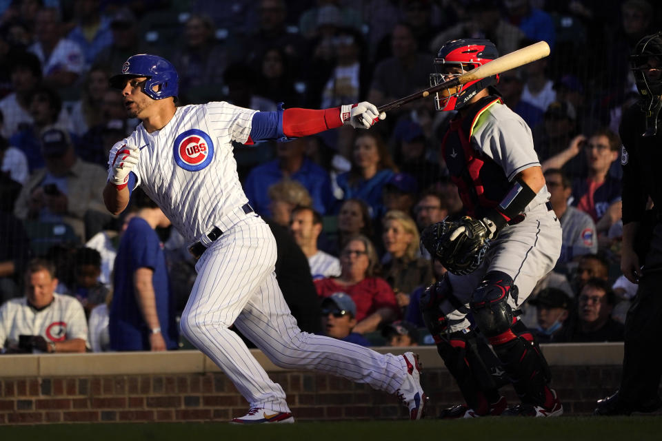 Chicago Cubs' Willson Contreras, leeft, watches his double off Cleveland Indians' Aaron Civale as the sun sets over Wrigley Field during the second inning of a baseball game Monday, June 21, 2021, in Chicago. (AP Photo/Charles Rex Arbogast)