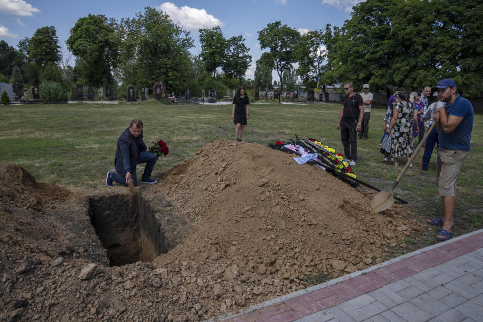 ARCHIVO - El alcalde de Pokrovsk, Ruslan Trebushkin, deja tierra sobre el ataúd de Volodymyr Miroshnychenko, de 40 años, fallecido en el frente en Marinka, tras su funeral en Pokrovsk, en el este de Ucrania, el viernes 15 de julio de 2022. Los ucranianos que viven en el camino de la invasión rusa, en asediada provincia oriental ucraniana de Donetsk, viven con la guerra cada día mientras se preparan para la posibilidad de evacuar. (AP Foto/Nariman El-Mofty, Archivo)