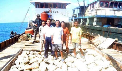 Philippine navy officers are pictured guarding Chinese fishermen aboard their fishing vessel loaded with giant shell clams which was intercepted off Scarborough Shoal, on April 11
