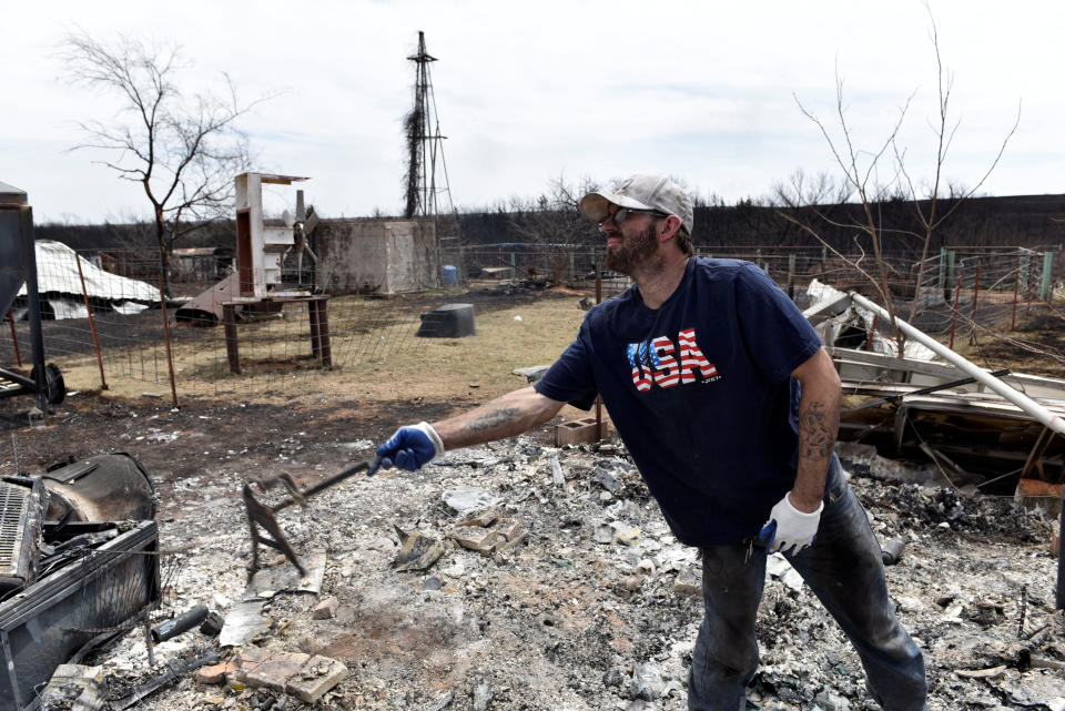 Johnny Lynes sifts through the remains of his parents home that was destroyed by the Rhea Fire near Taloga, Oklahoma. (Photo: Nick Oxford / Reuters)