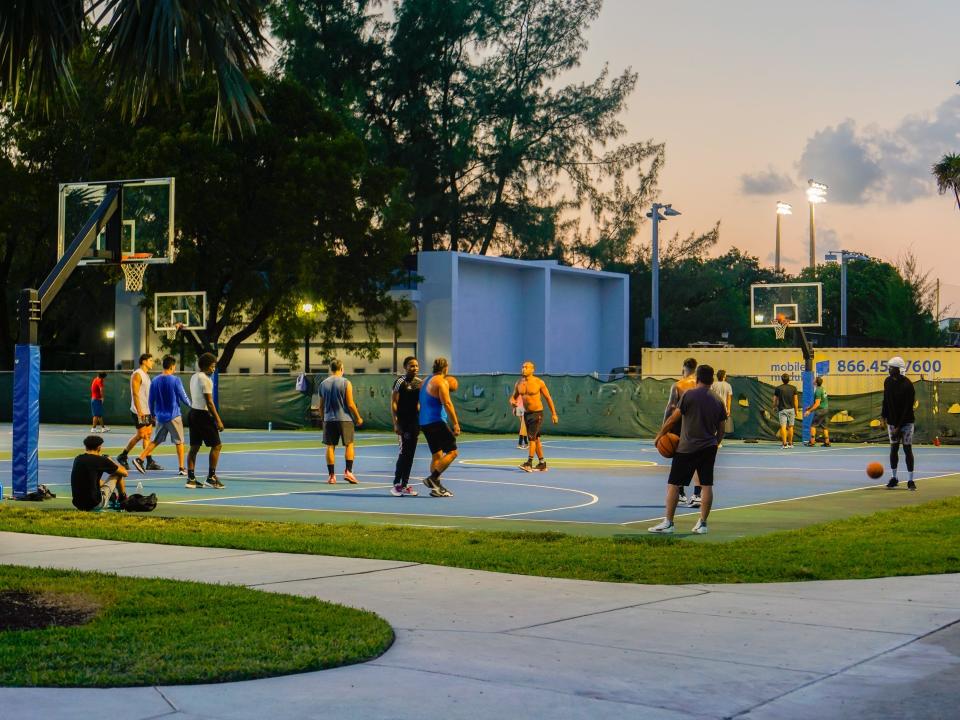 People play basketball at a public park in Miami