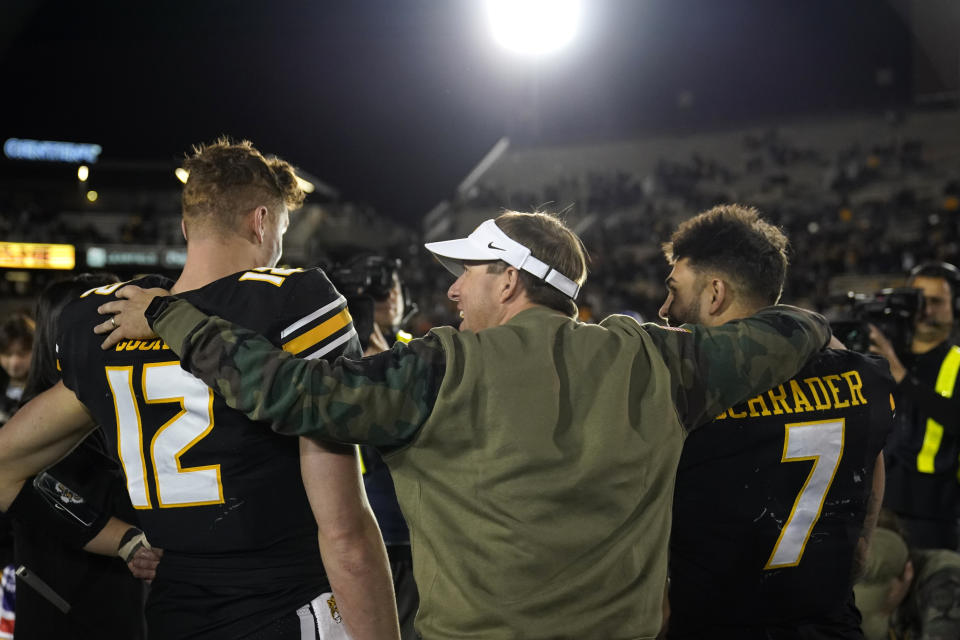 Missouri head coach Eli Drinkwitz, center, hugs Missouri quarterback Brady Cook (12) and running back Cody Schrader (7) following a win over Tennessee Saturday, Nov. 11, 2023, in Columbia, Mo. (AP Photo/Jeff Roberson)