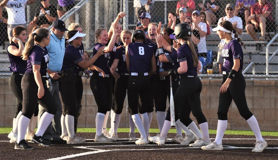 Wylie players congratulate Mycala Reed (8) as she scores after hitting a solo home run for the game's first run in the third inning against Cooper. The Lady Bulldogs won the District 4-5A game 6-4 on April 5 at Cougar Diamond.