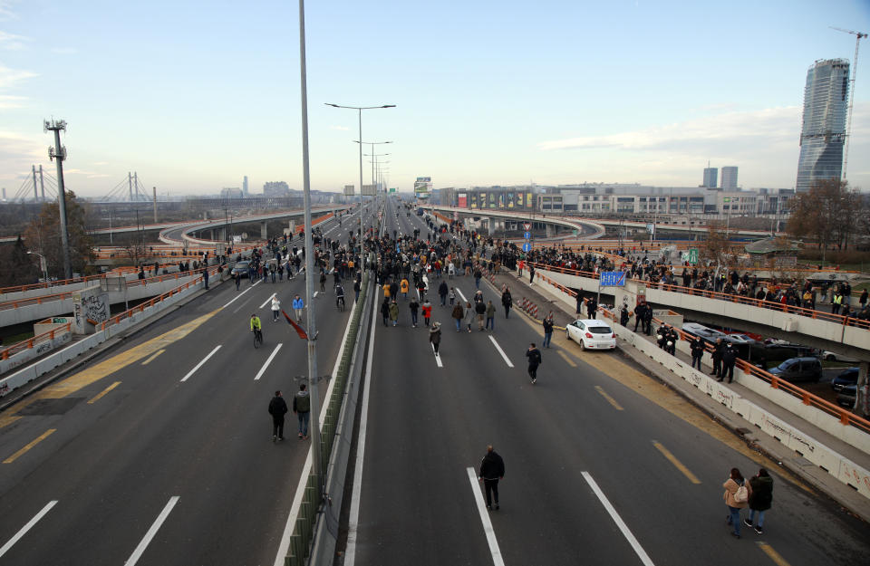 Protesters stand on the highway during protest in Belgrade, Serbia, Saturday, Nov. 27, 2021. Skirmishes on Saturday erupted in Serbia between police and anti-government demonstrators who blocked roads and bridges in the Balkan country in protest against new laws they say favor interests of foreign investors devastating the environment. (AP Photo/Milos Miskov)