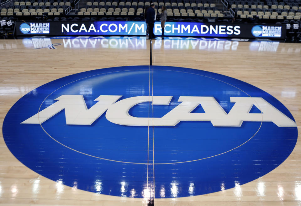 FILE - In this March 18, 2015, file photo, the NCAA logo is displayed at center court as work continues at The Consol Energy Center in Pittsburgh, for the NCAA college basketball tournament. A bill being introduced Thursday, Dec. 17, 2020, by four Democratic lawmakers would grant college athletes sweeping rights to compensation, including a share of the revenue generated by their sports, and create a federal commission on college athletics. The College Athletes Bill of Rights is sponsored by U.S. Senators Corey Booker (D-N.J.), Richard Blumenthal (D-Conn.) and Kirsten Gillibrand (D-N.Y.), and U.S. Rep. Jan Schakowsky (D-Ill.). If passed it could wreak havoc with the NCAA's ability to govern intercollegiate athletics, and the association's model for amateurism. (AP Photo/Keith Srakocic, File)