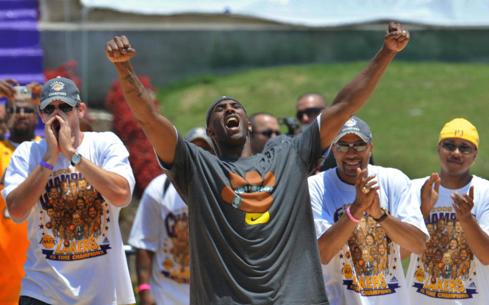 Los Angeles Lakers player Kobe Bryant (dark shirt) celebrates with other players during a victory parade at the Coliseum stadium in Los Angeles after defeating the Orlando Magic in the NBA final series, on June 17, 2009.  The Lakers won the series 4-1             AFP PHOTO/Mark RALSTON (Photo credit should read MARK RALSTON/AFP via Getty Images)