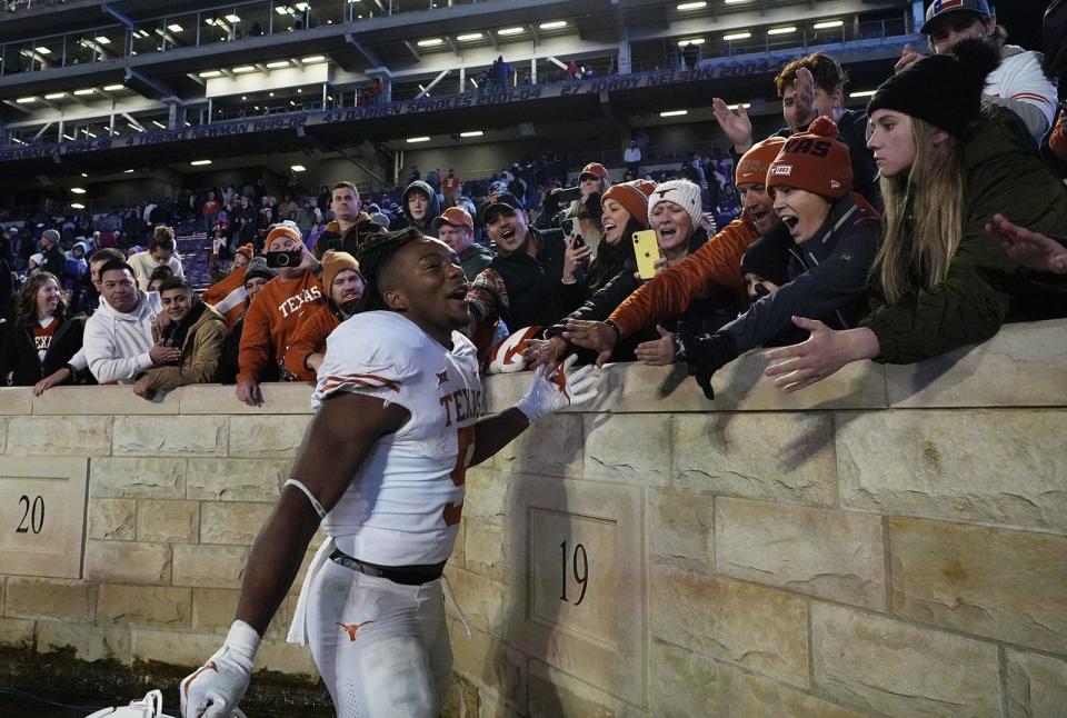 Texas running back Bijan Robinson celebrates with fans after Saturday night's win over Kansas State at Bill Snyder Family Stadium in Manhattan, Kan. Robinson finished with 209 rushing yards, the second-best performance of his UT career.