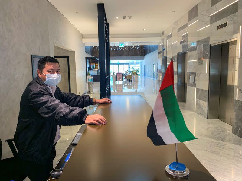 A security guard wears a face mask, amid fear of coronavirus disease (COVID-19) outbreak, at the entrance of almost an empty building in Media City in Dubai