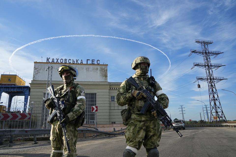 Russian troops guard an entrance of the Kakhovka Hydroelectric Station, a run-of-the-river power plant on the Dnieper River in Kherson region, southern Ukraine, Friday, May 20, 2022, during a trip organized by the Russian Ministry of Defense. The Kherson region has been under control of the Russian forces since the early days of the Russian military action in Ukraine. (AP Photo)