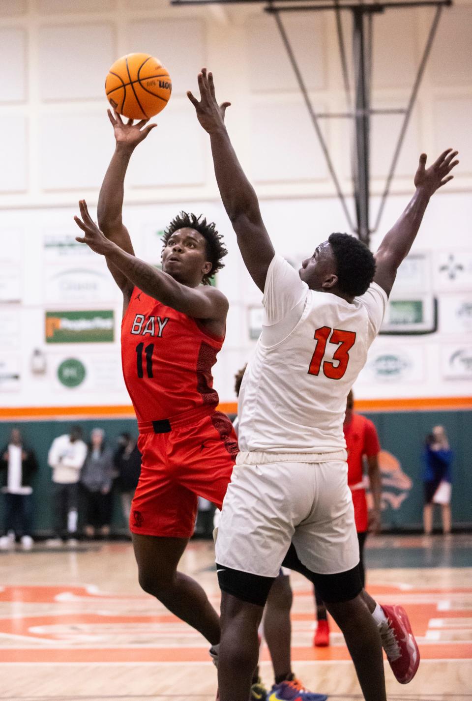 Bay senior Tyberias McCree sweeps in for a shot past Mosley junior Randy Pittman. Mosley hosted Bay in a boys basketball game Friday, January 14, 2022. Bay left with the win, 58-46.