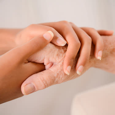 Young-womans-hands-holding-tenederly-hand-of-an-elderly-person_web