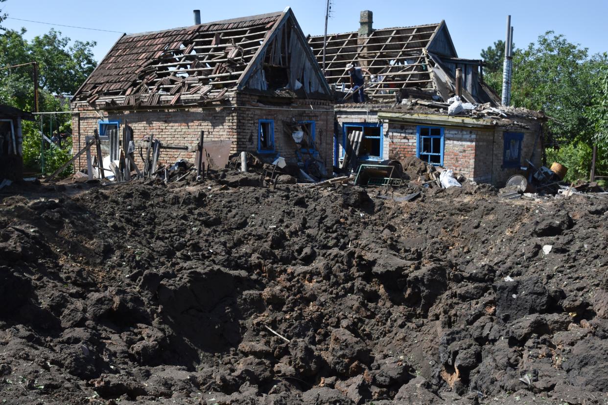 A crater is seen next to houses damages by Russian shelling in Kushuhum, near Zaporizhia (AP)