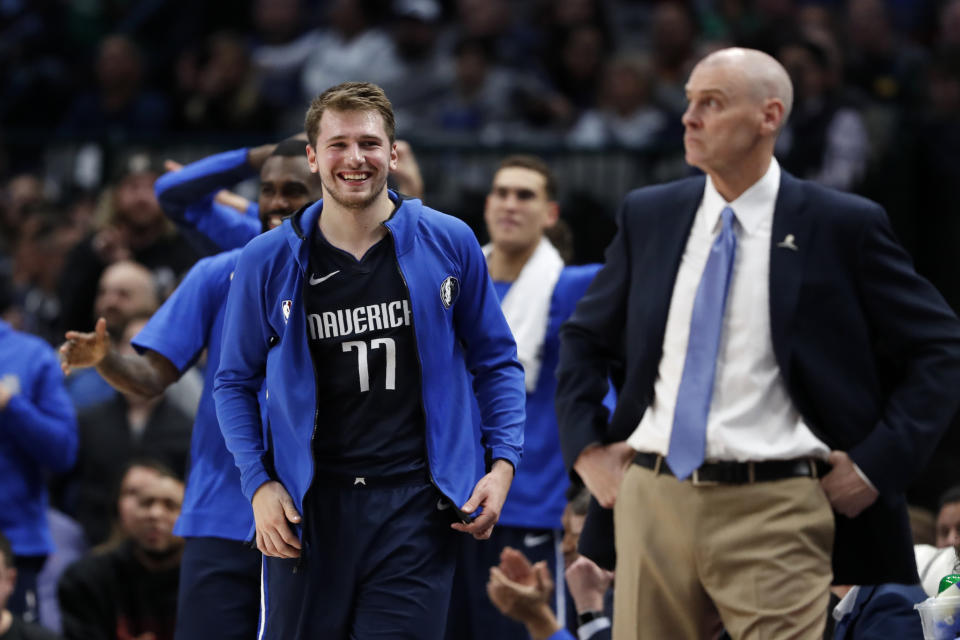 Dallas Mavericks forward Luka Doncic (77) stands by the bench smiling next to head coach Rick Carlisle, right, late in the second half of an NBA basketball game against the Cleveland Cavaliers in Dallas, Friday, Nov. 22, 2019. Doncic scored a game-high 30 points, 14 assist and 7 rebounds in the 143-101 Mavericks win. (AP Photo/Tony Gutierrez)