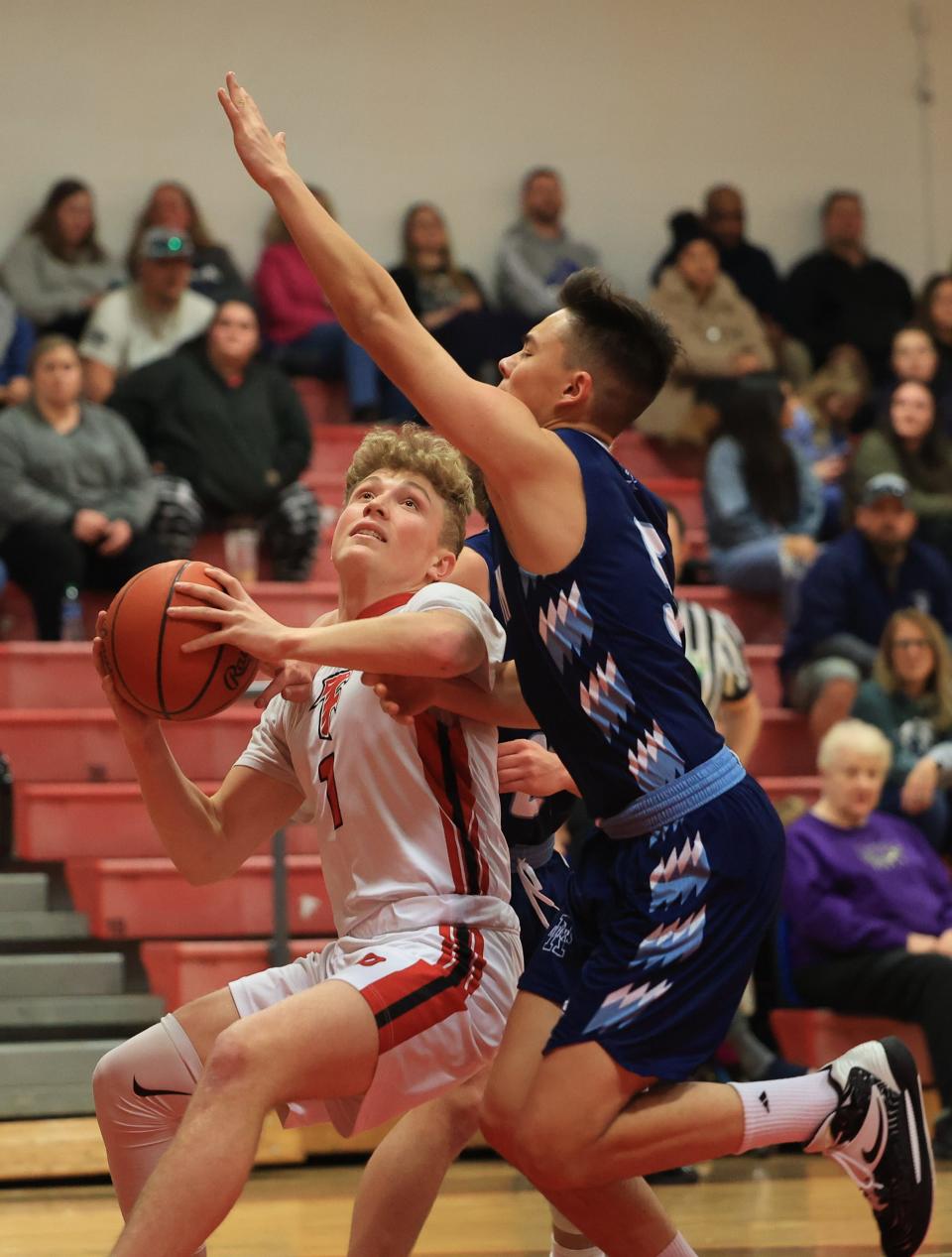 Field junior Braxton Baumberger pulls up to take a shot while Rootstown junior Cole Hostetler goes up to block during Tuesday night’s game at Field High School. Field defeated Rootstown 61-50.